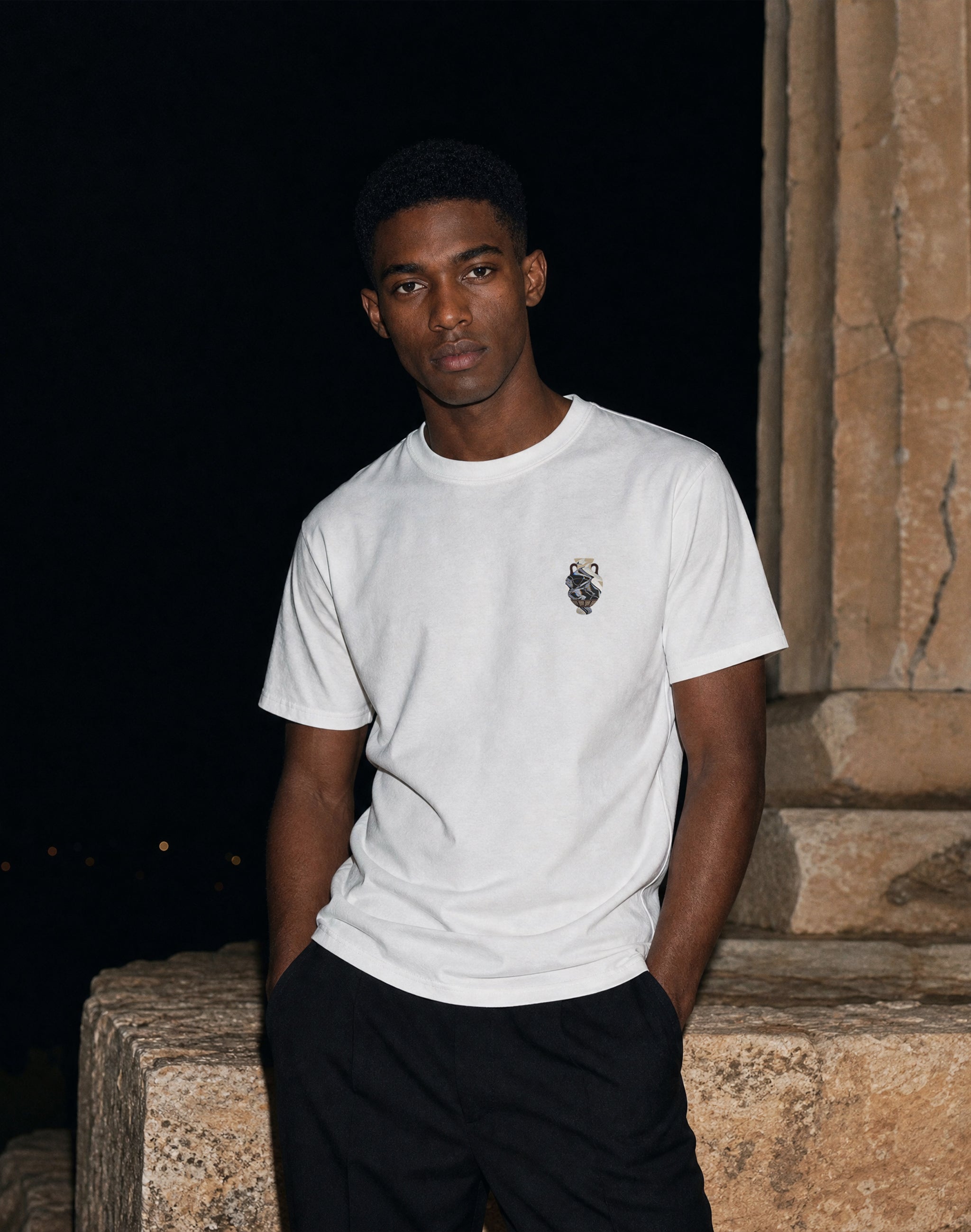 Amphora 02 T-Shirt white front print worn by male model at a greek ruin flash photography night time— PERAMA Odyssey