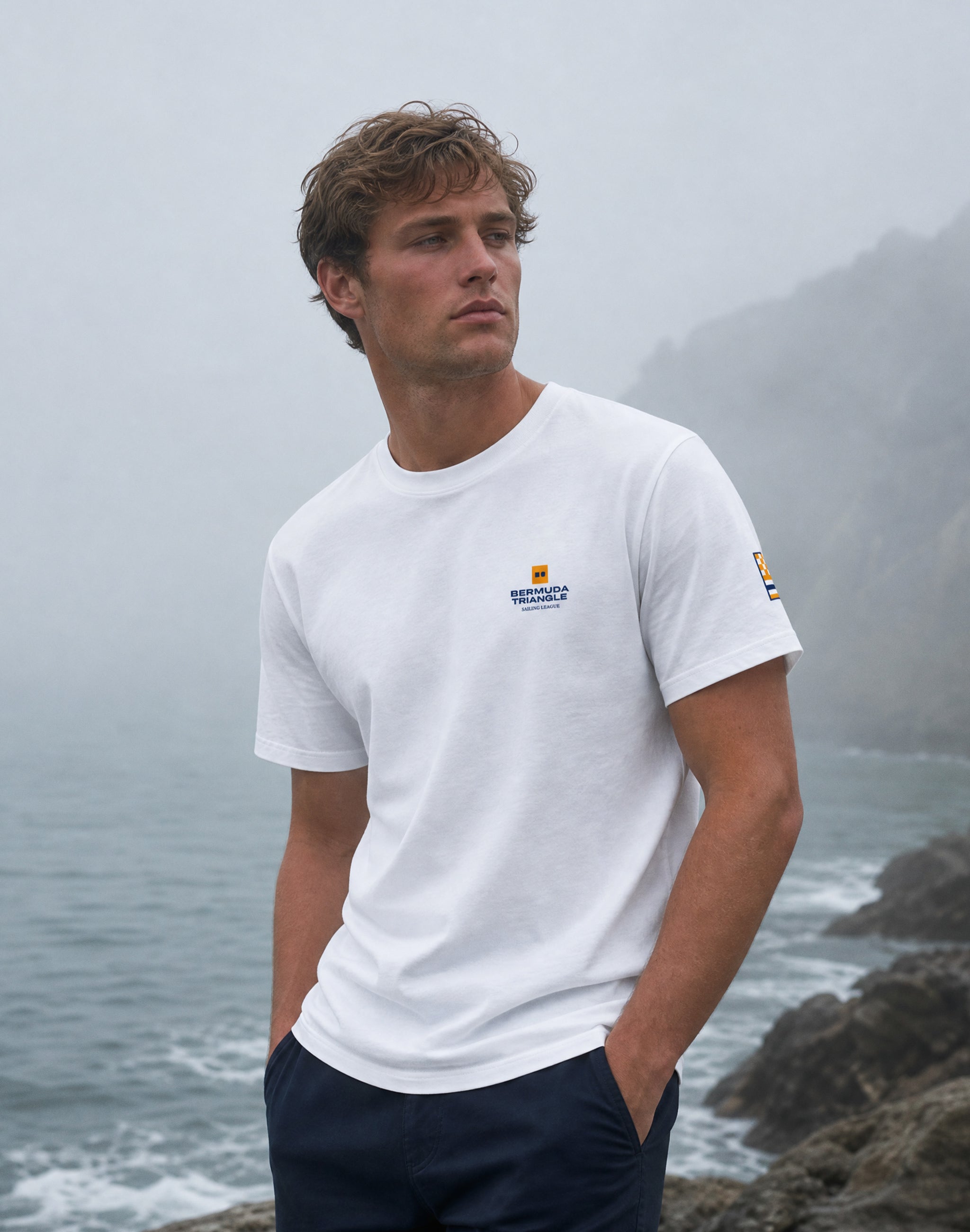 Bermuda triangle sailing white-front worn by male model at the seaside surrounded by fog — PERAMA Sport Federation