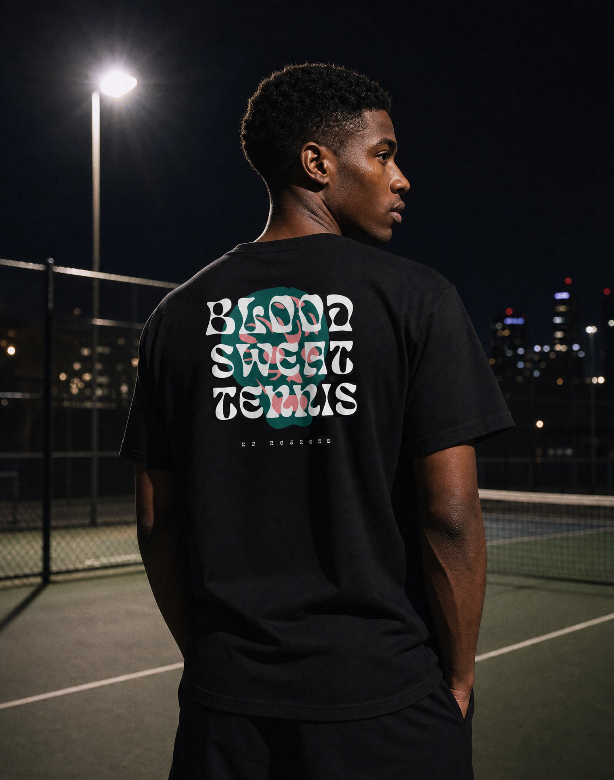 Blood Sweat Tennis no regrets worn by male model at city tennis court night flood lights — PERAMA Classics