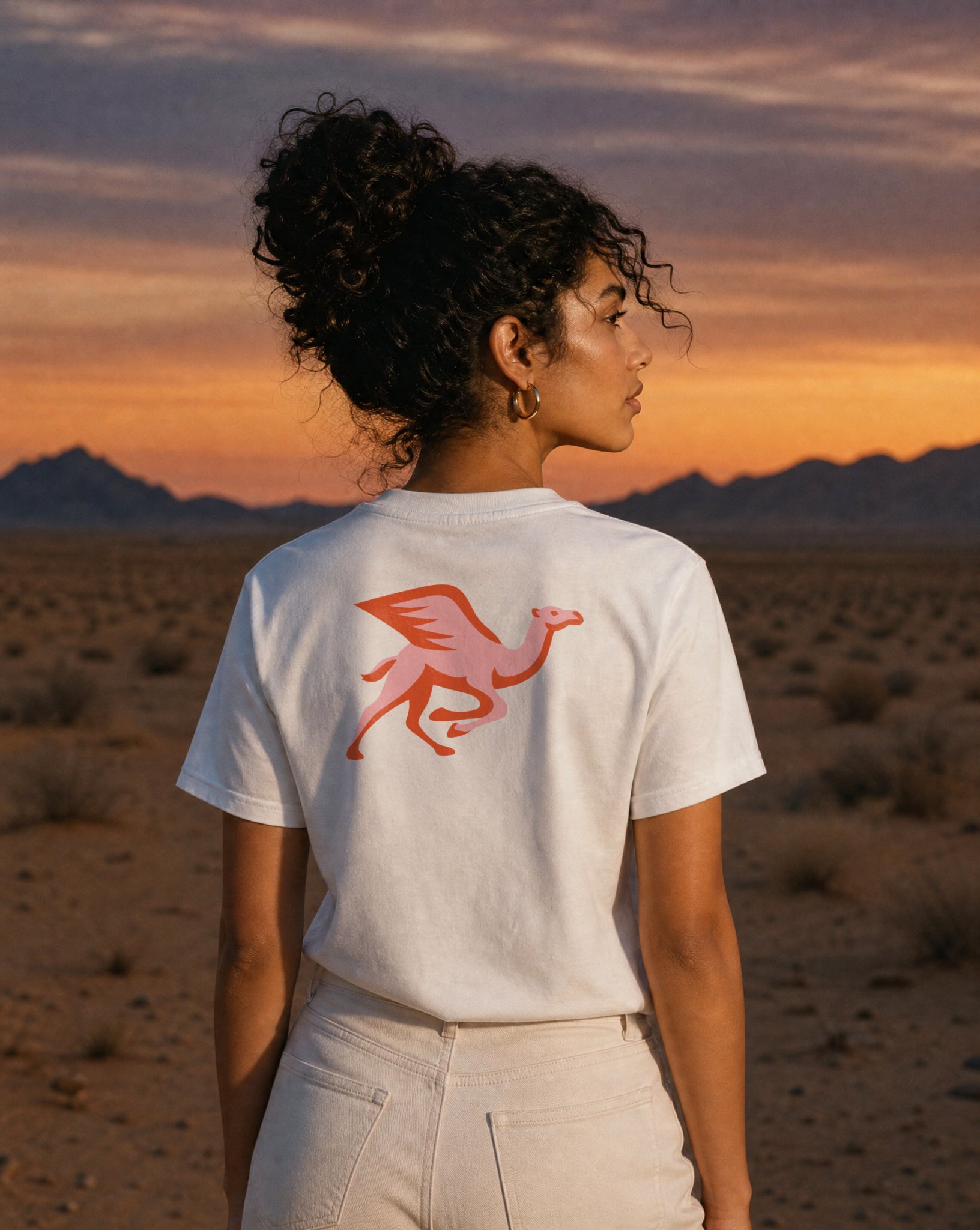 Helsinki Camel Racing League Crest t-shirt worn in open wilderness at sunset — PERAMA Sports Federation