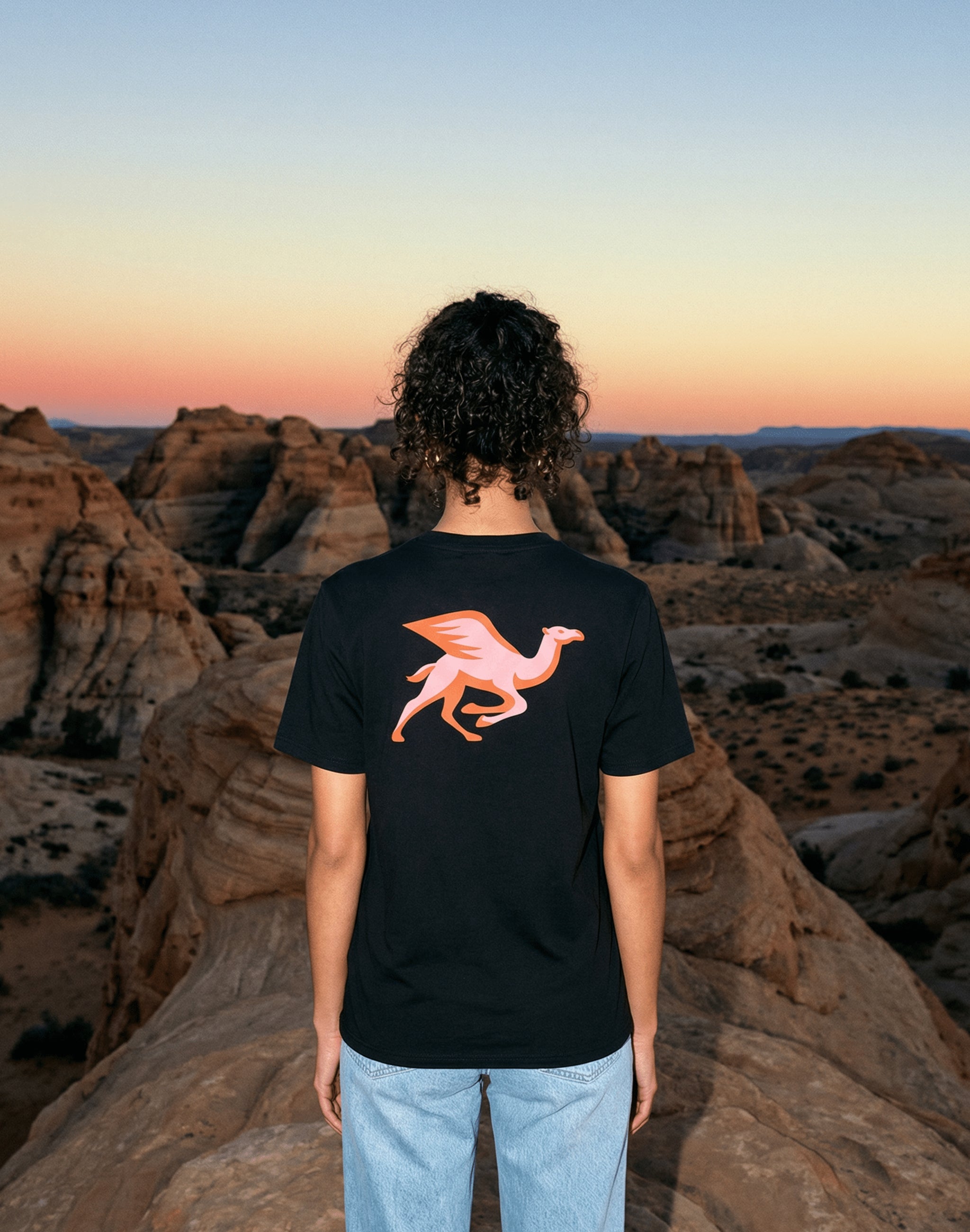 Helsinki Camel Racing League Crest t-shirt worn in open wilderness at sunset — PERAMA Sports Federation