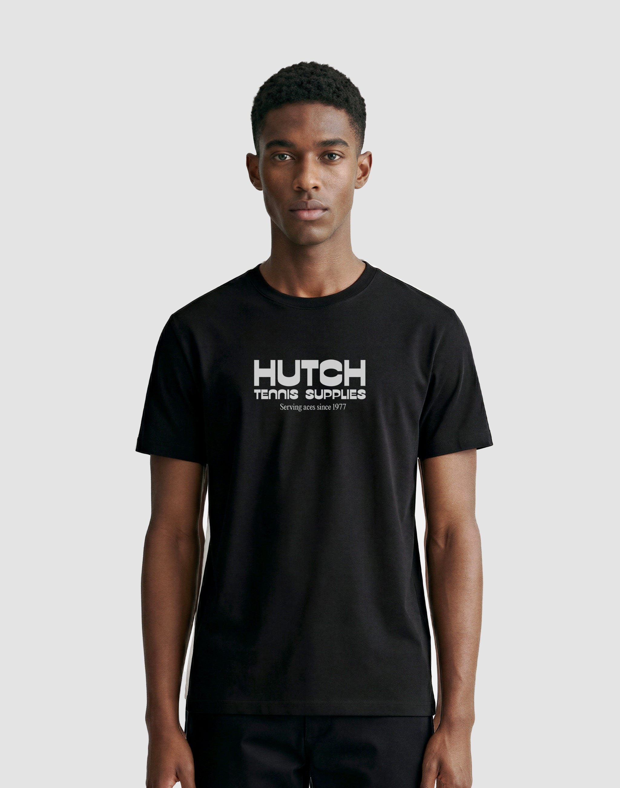 Hutch Tennis Supplies T-Shirt black middle chest print sponsor worn by male model — PERAMA Sponsors