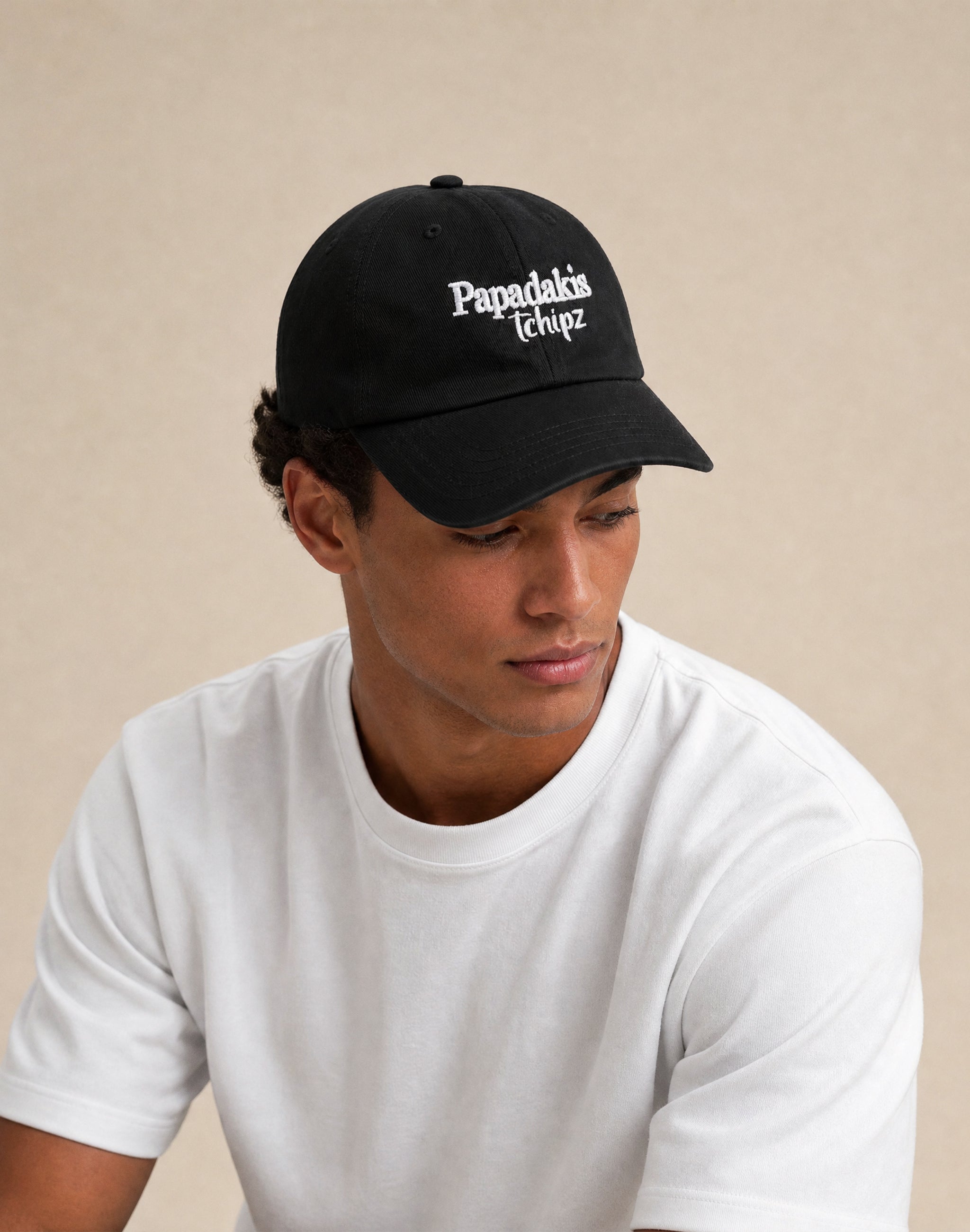 Papadakis Tchipz embroidered black cap worn by model in studio — PERAMA Sponsors
