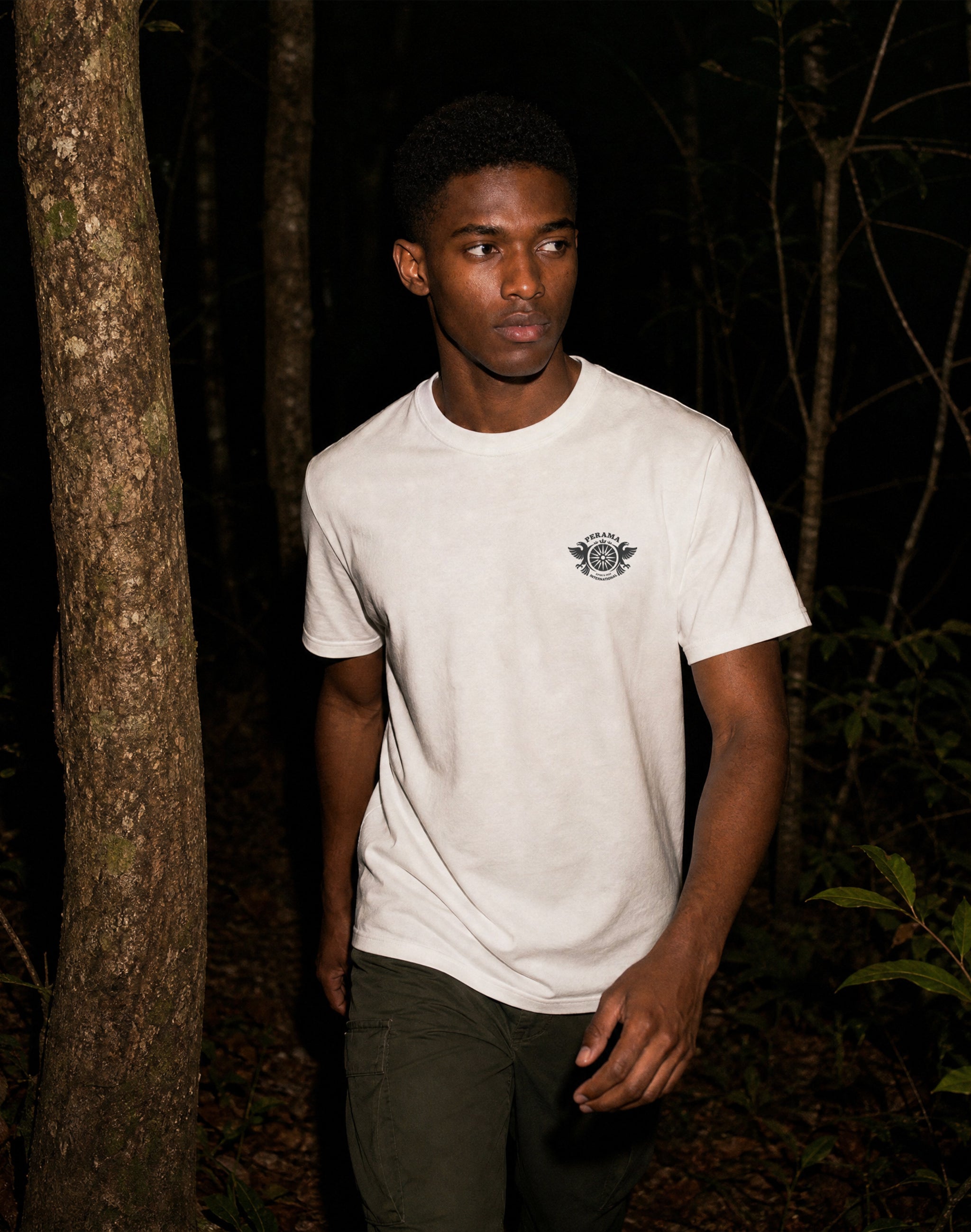 perama international Epirus 1950 federation logo front white t shirt worn by male model in Epirus forest — PERAMA INTERNATIONAL
